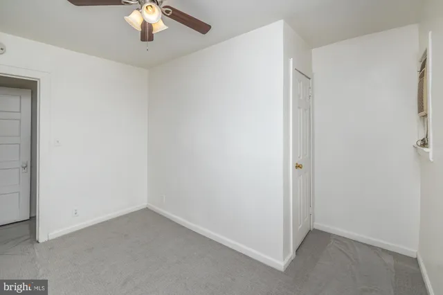 an empty room with a chandelier fan