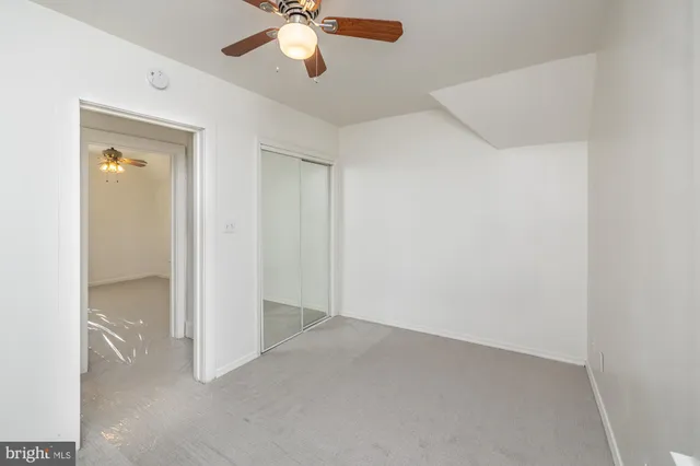 an empty room with a empty space and a ceiling fan