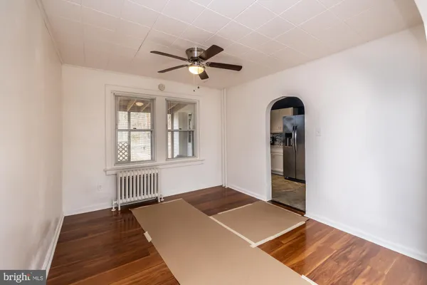 an empty room with windows and ceiling fan