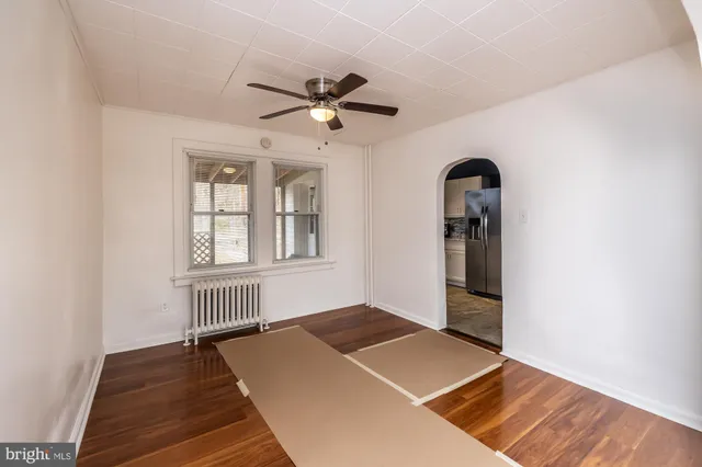 an empty room with windows and ceiling fan