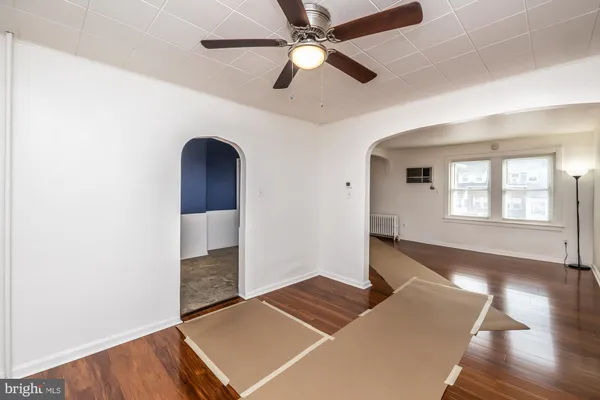 a living room with hard wood floors and a ceiling fan