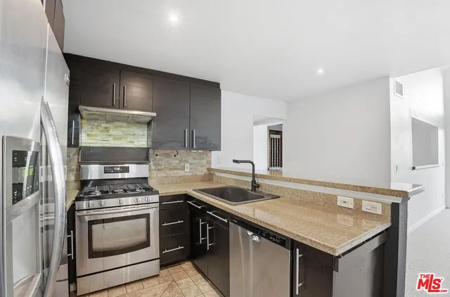 a kitchen with granite countertop a sink stove and cabinets
