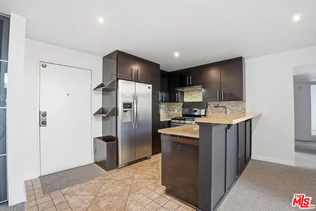 a kitchen with stainless steel appliances granite countertop a refrigerator and a stove