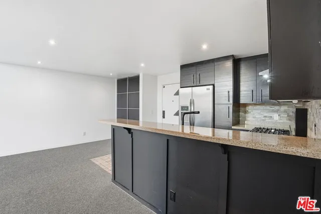 a kitchen with stainless steel appliances a sink stove and cabinets