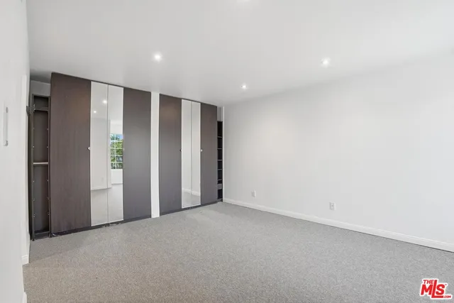 an empty room with closet and wooden floor