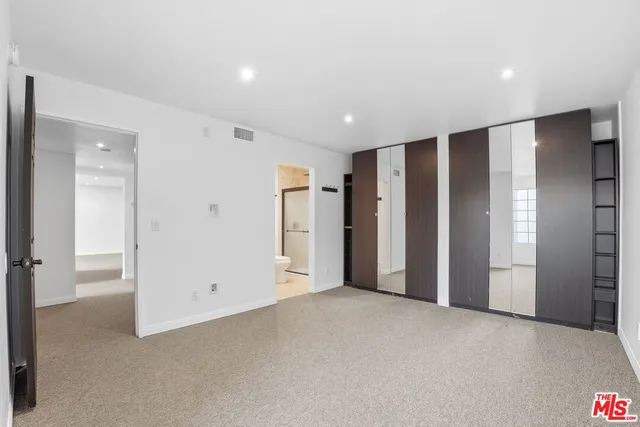 an empty room with closet and wooden floor