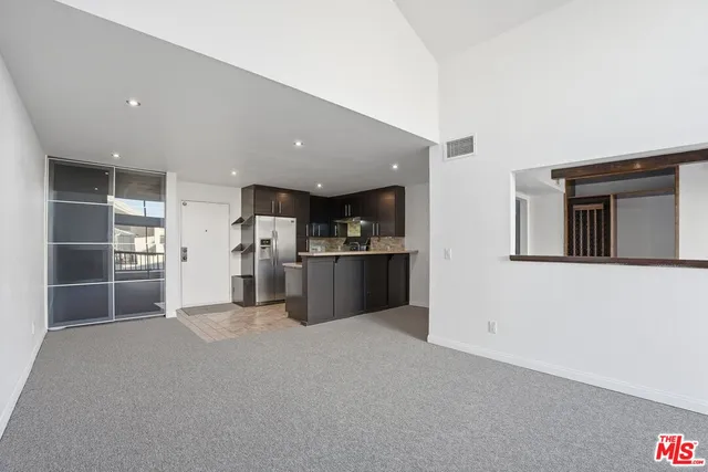 a view of a kitchen with refrigerator and a sink