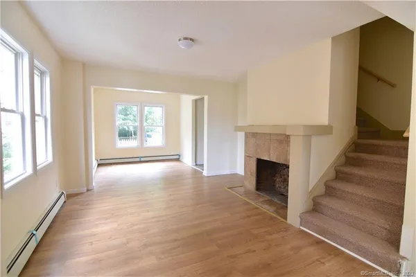a view of a livingroom with wooden floor fireplace and windows
