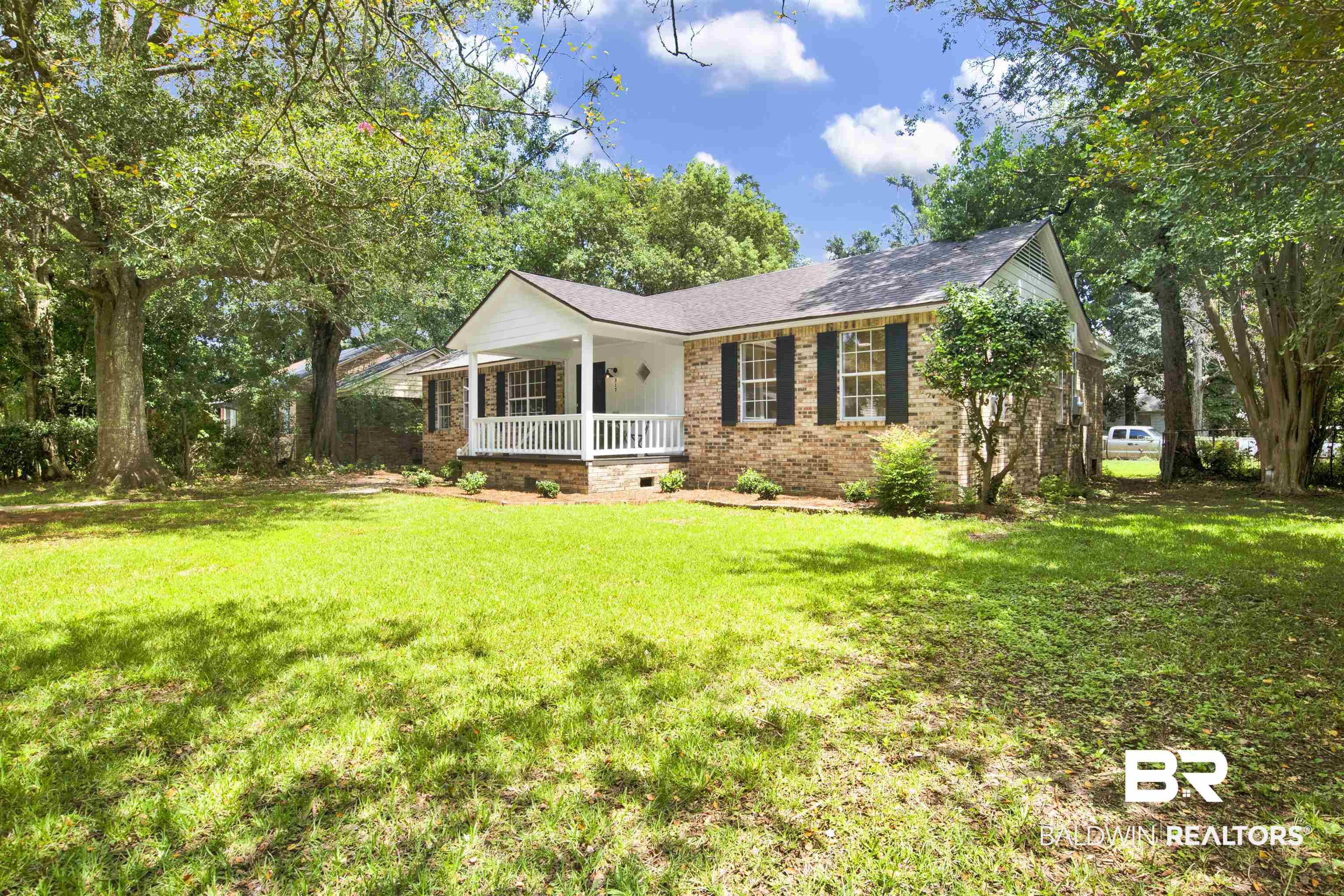 317 Lee Street Chickasaw, AL 36611 - Photo 40 of 40 View of front facade featuring a porch, a front yard, brick siding, and new roof with shingles