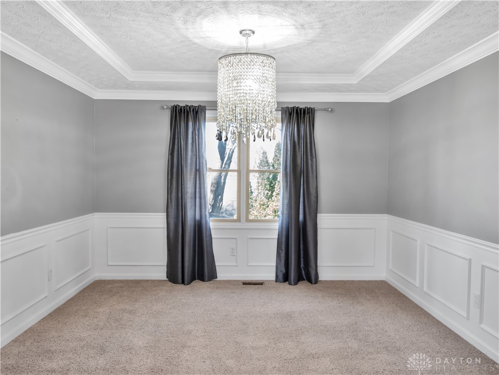 25 Callaway Springboro, OH 45066 - Photo 22 of 51 This inviting room features a dazzling chandelier, crown molding, and wainscoting, creating an elegant and comfortable atmosphere.