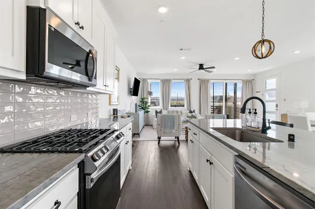 a kitchen with stainless steel appliances a sink a stove top oven a counter space and cabinets