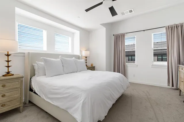 a large bed sitting in a bedroom next to a window and a dresser