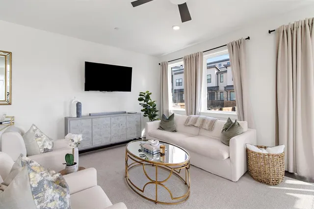 a living room with furniture a flat screen tv and a window