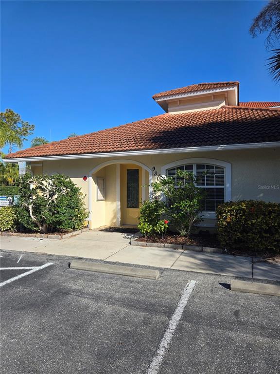 960 Cooper Street, Unit 203 Venice, FL 34285 - Photo 34 of 39 a front view of a house with a yard and potted plants