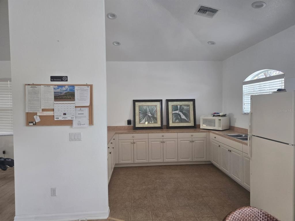 960 Cooper Street, Unit 203 Venice, FL 34285 - Photo 37 of 39 a kitchen with white cabinets and white appliances