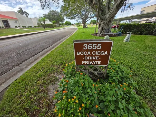 a sign board with a play ground in the back yard