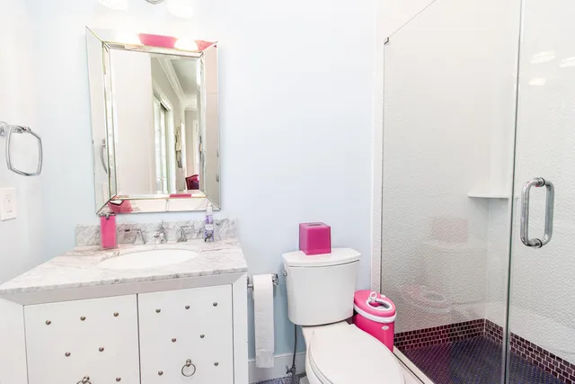 a bathroom with a sink vanity mirror and toilet