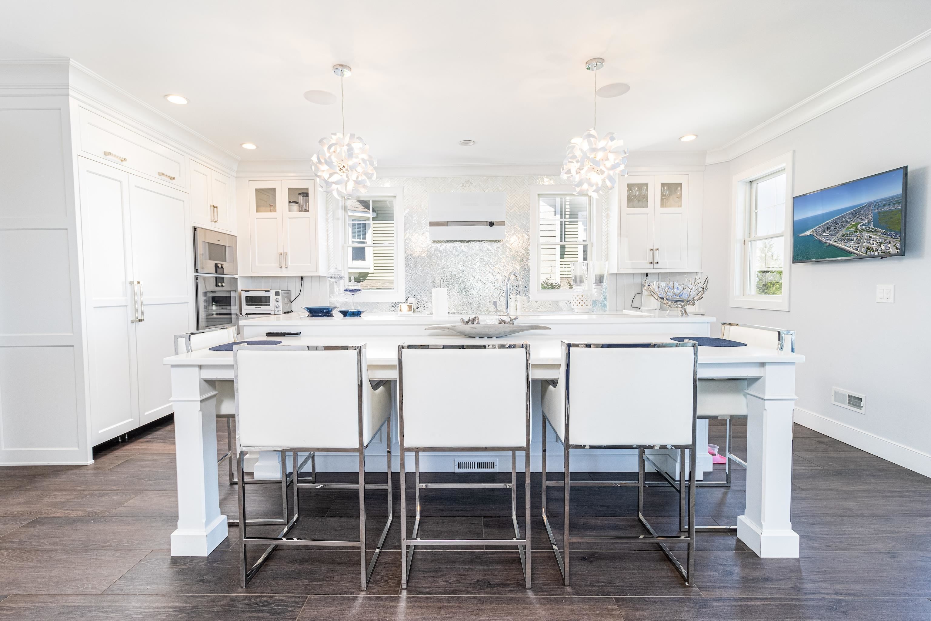 415 20th Avalon, NJ 08202 - Photo 13 of 50 a white kitchen with a dining table chairs and white cabinets