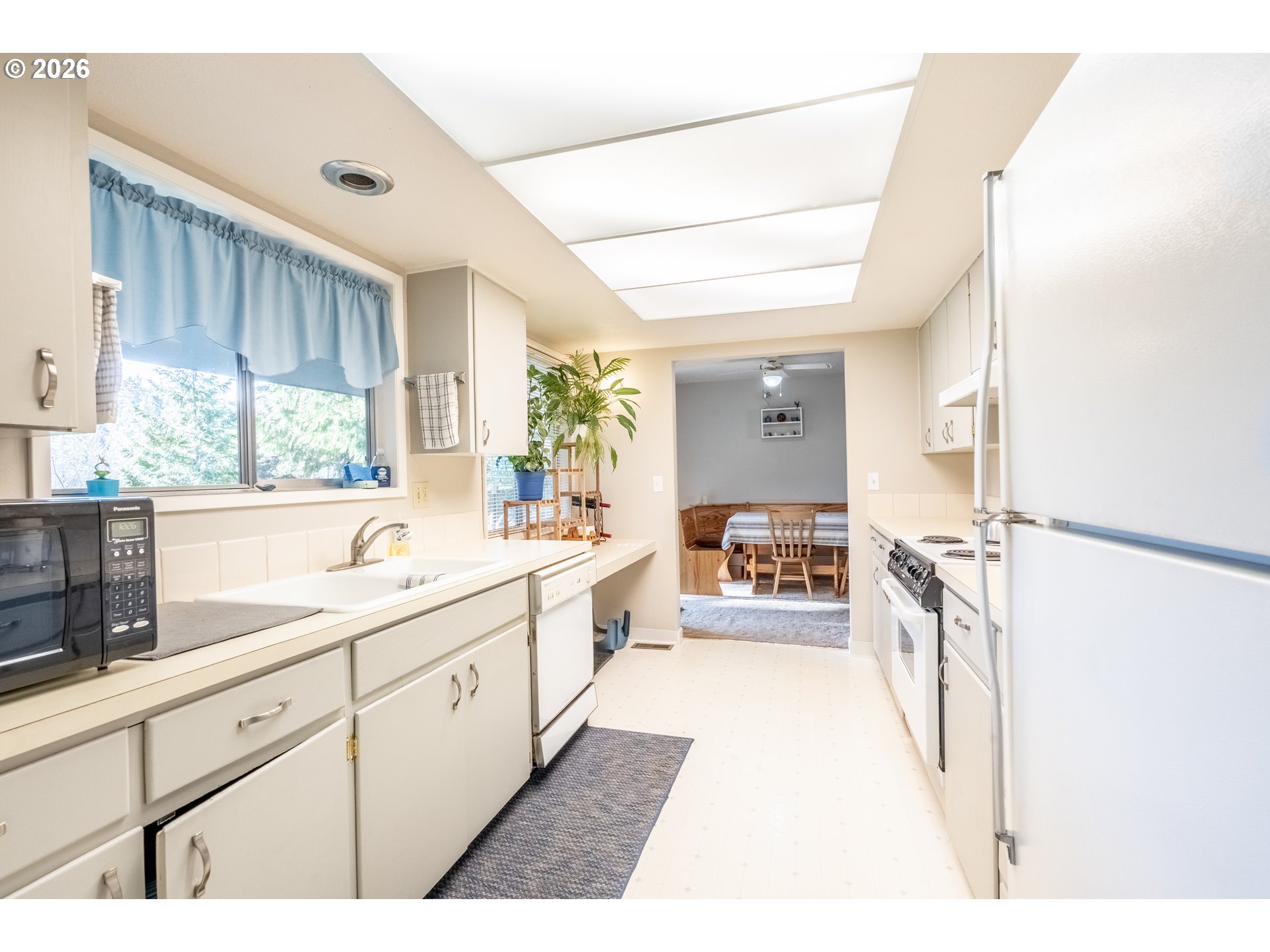10480 Southwest Meadow Street Tigard, OR 97223 - Photo 3 of 20 a large white kitchen with a large window