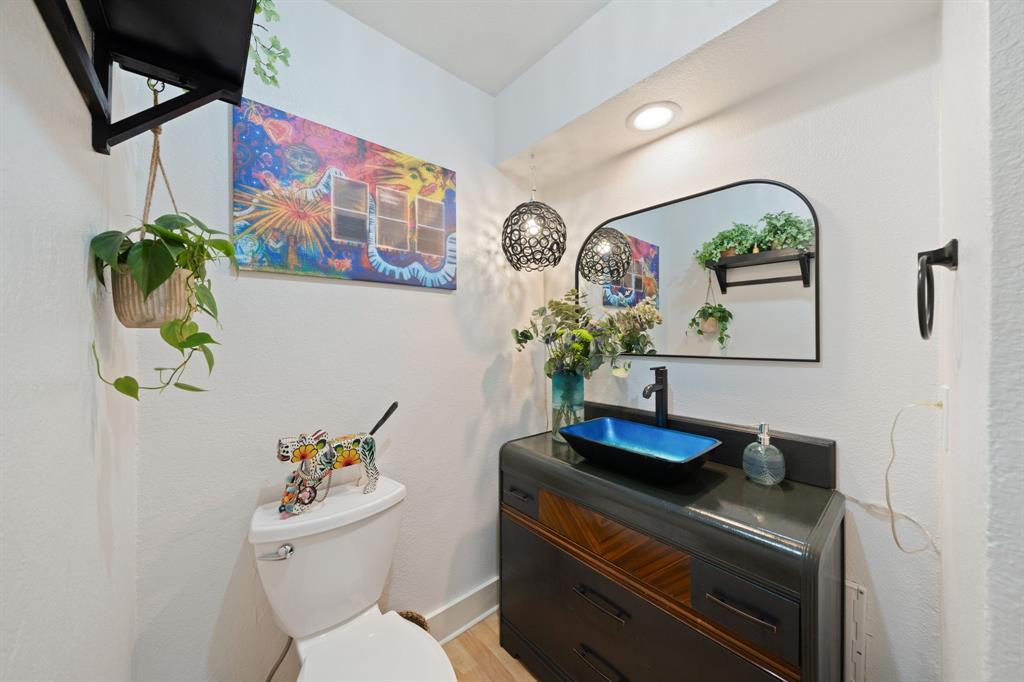 7496 East Northwest Highway, Unit 145 Dallas, TX 75231 - Photo 13 of 35 a bathroom with a toilet sink and mirror