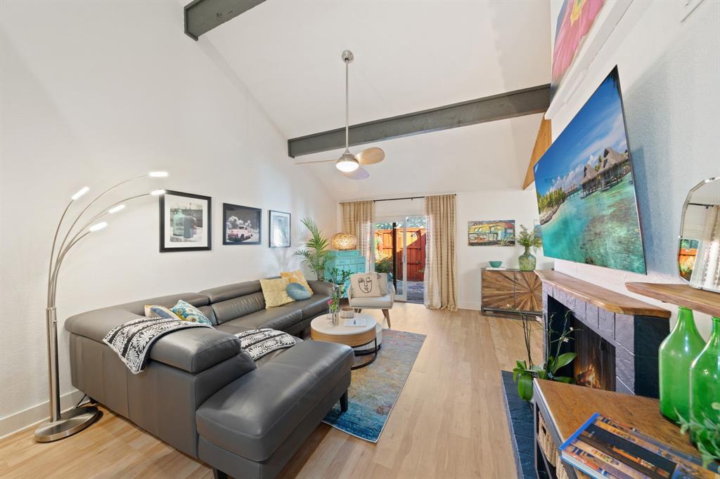 7496 East Northwest Highway, Unit 145 Dallas, TX 75231 - Photo 10 of 35 a living room with furniture a fireplace and a floor to ceiling window