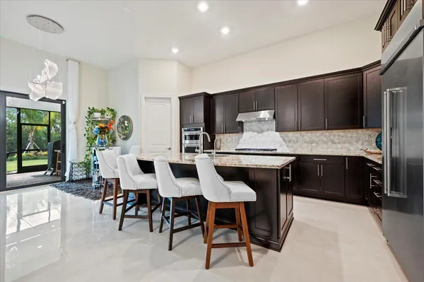 a kitchen with a dining table chairs and refrigerator
