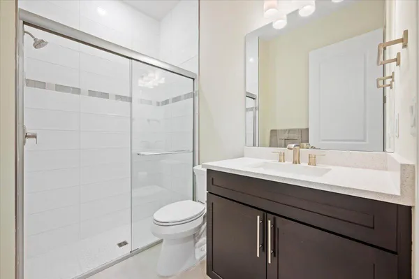 a bathroom with a sink a toilet and shower