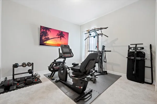 a room with gym equipment and a view of living room