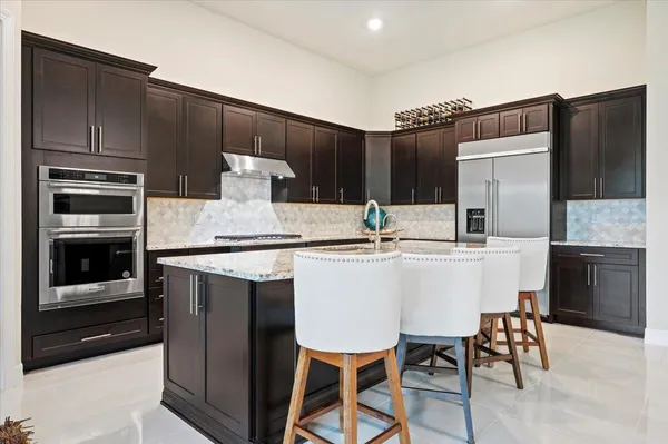 a kitchen with a table chairs refrigerator and microwave