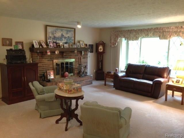 2198 West Barron Road Howell, MI 48855 - Photo 11 of 25 living room with fireplace and large windows