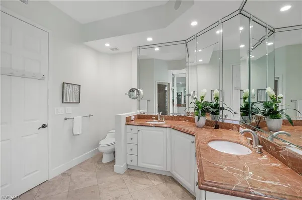 a bathroom with a granite countertop sink mirror and toilet