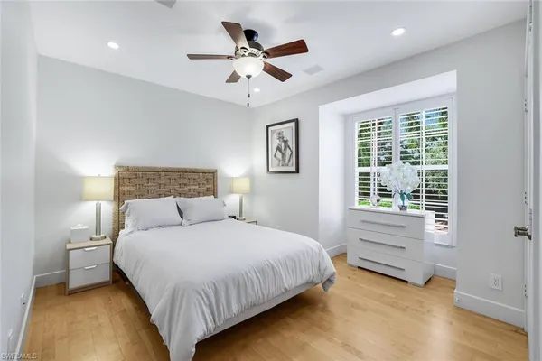 a bedroom with a large bed chandelier and a window