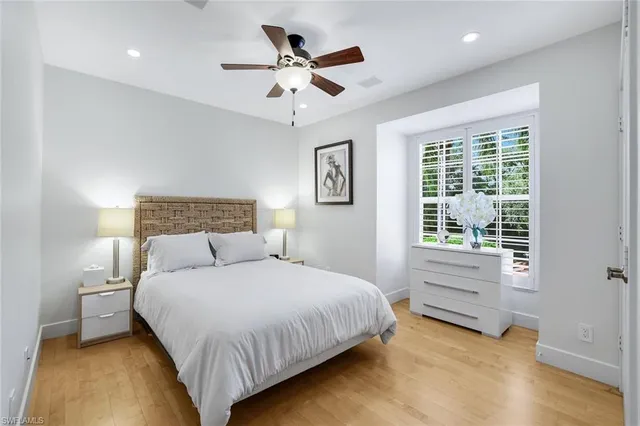 a bedroom with a large bed chandelier and a window