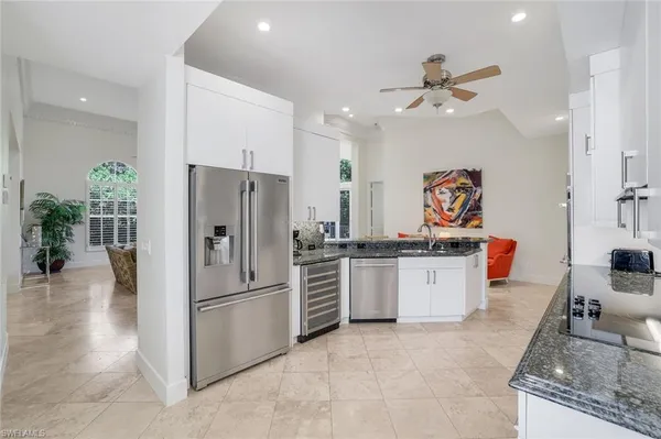 a kitchen with stainless steel appliances granite countertop a refrigerator and a sink
