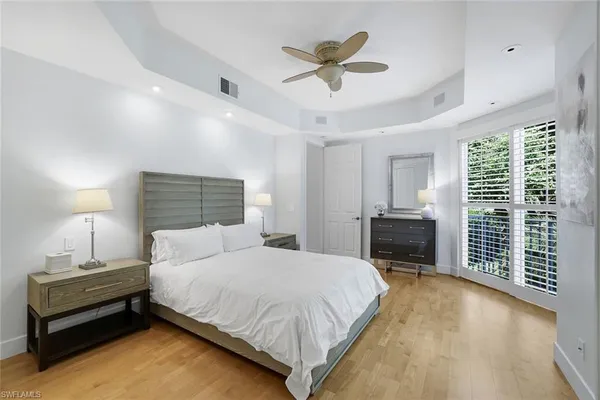 a bedroom with a large bed chandelier and a window