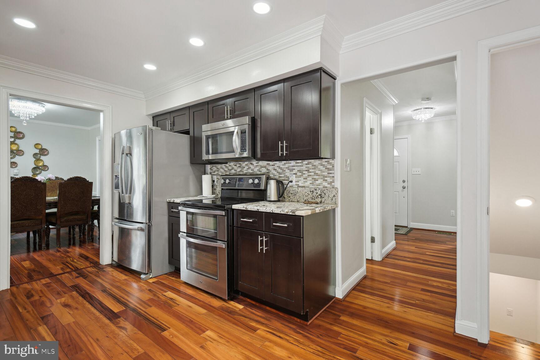 12324 Triple Crown Road North Potomac, MD 20878 - Photo 19 of 49 a kitchen with stainless steel appliances granite countertop a refrigerator and a stove top oven