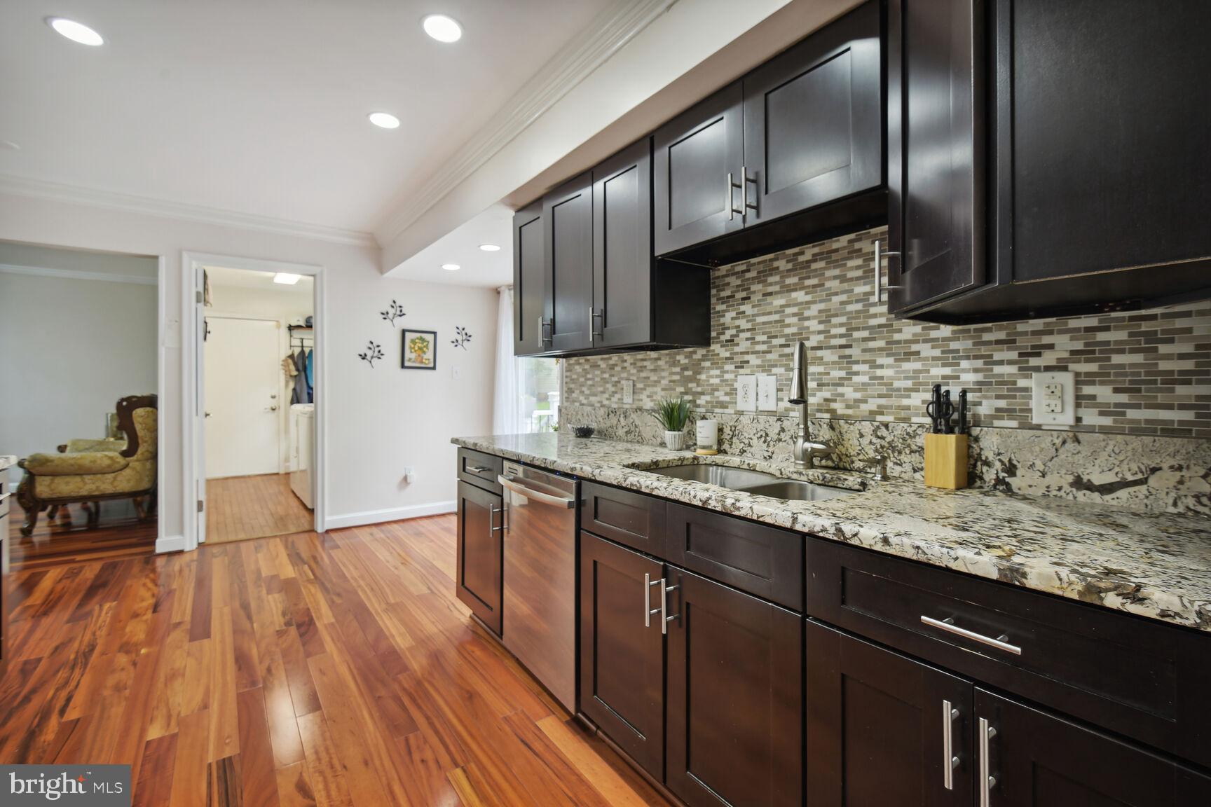 12324 Triple Crown Road North Potomac, MD 20878 - Photo 20 of 49 a kitchen with granite countertop wooden floors wooden cabinets and stainless steel appliances