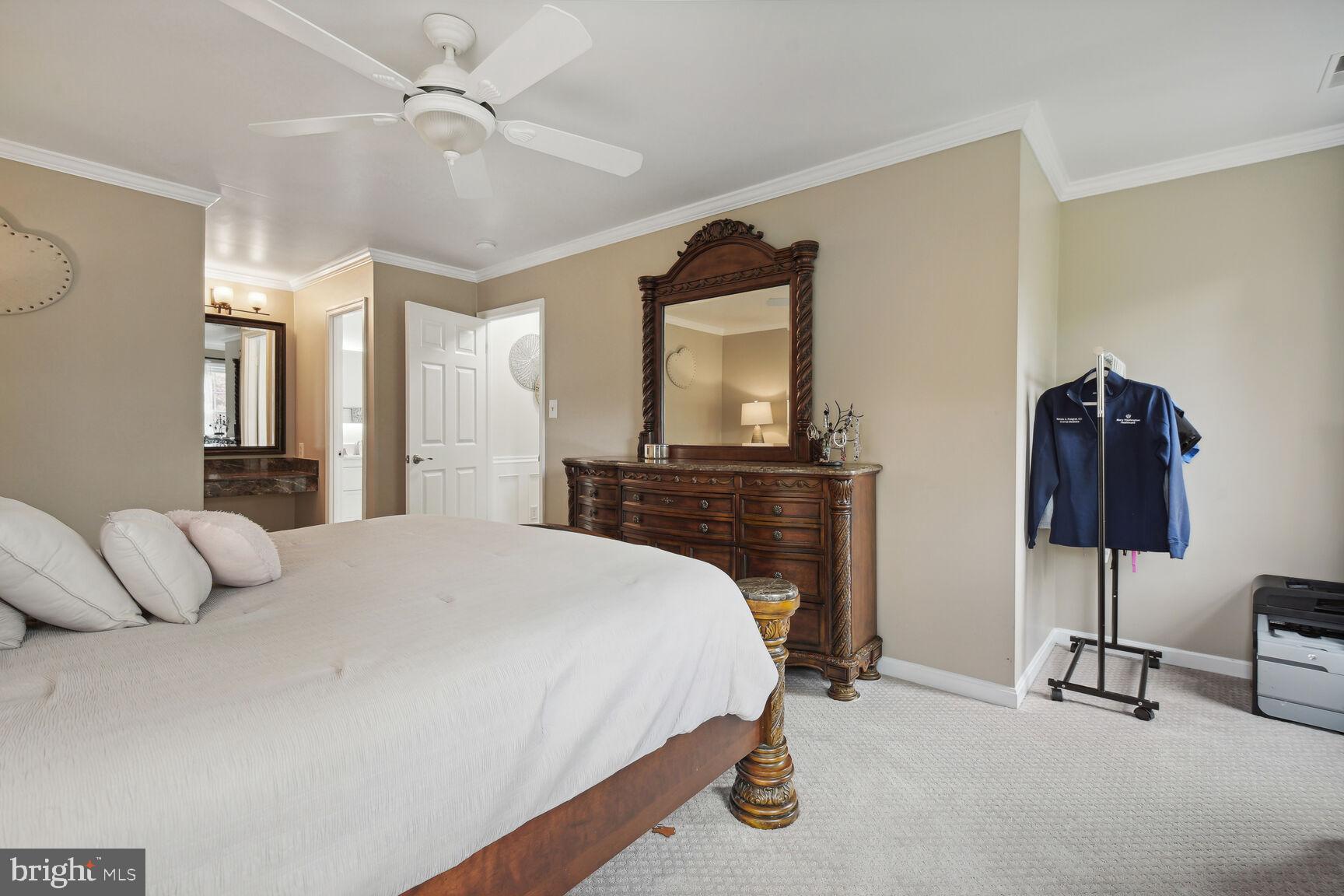 12324 Triple Crown Road North Potomac, MD 20878 - Photo 23 of 49 a bedroom with a bed a chandelier and a dresser