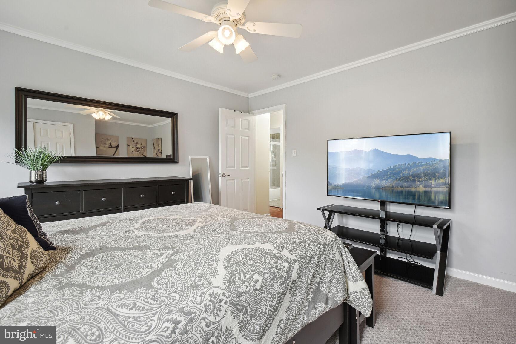 12324 Triple Crown Road North Potomac, MD 20878 - Photo 26 of 49 a bedroom with a bed and a chandelier