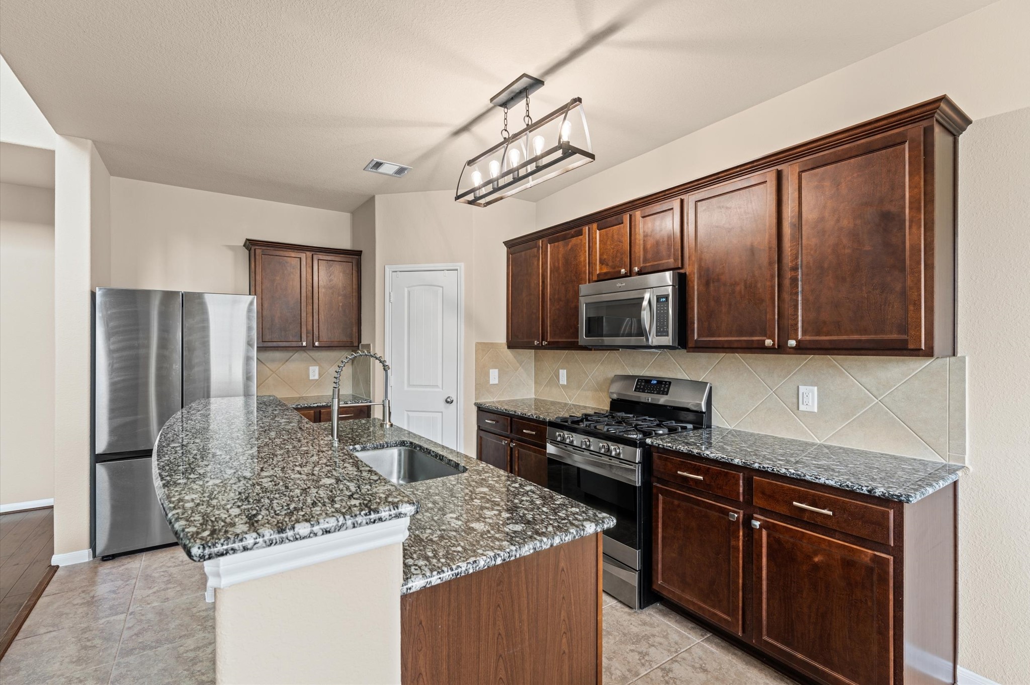 22534 Rustic Valley Court Porter, TX 77365 - Photo 6 of 27 a kitchen with stainless steel appliances granite countertop a sink stove microwave and refrigerator