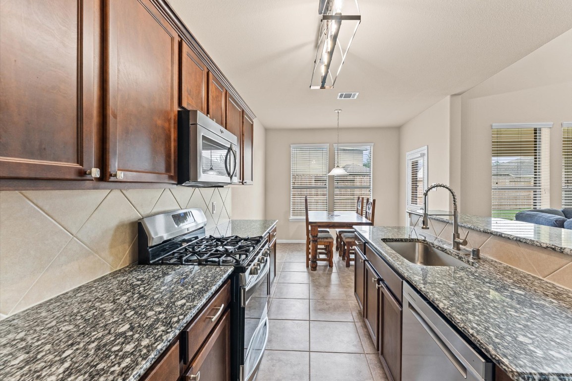 22534 Rustic Valley Court Porter, TX 77365 - Photo 7 of 27 a kitchen with stainless steel appliances granite countertop a sink stove and cabinets