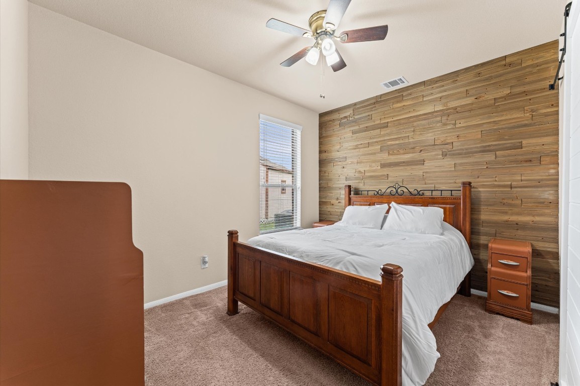 22534 Rustic Valley Court Porter, TX 77365 - Photo 10 of 27 a bedroom with a bed and a chandelier