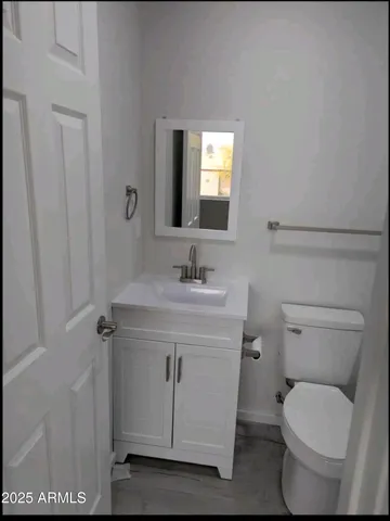 a bathroom with a toilet a sink and mirror