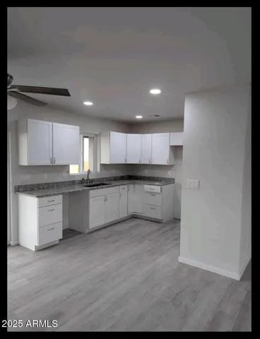 a large kitchen with stainless steel appliances granite countertop a stove a sink and a refrigerator