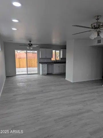 a view of empty room with window and wooden floor