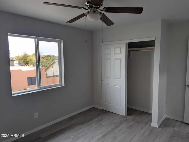 an empty room with a window and a ceiling fan