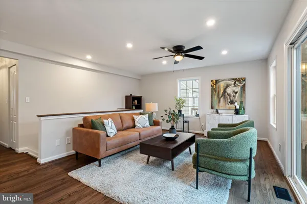 a living room with furniture and a ceiling fan