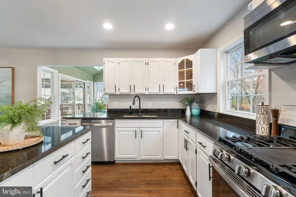 a large kitchen with stainless steel appliances granite countertop a stove a sink and a refrigerator