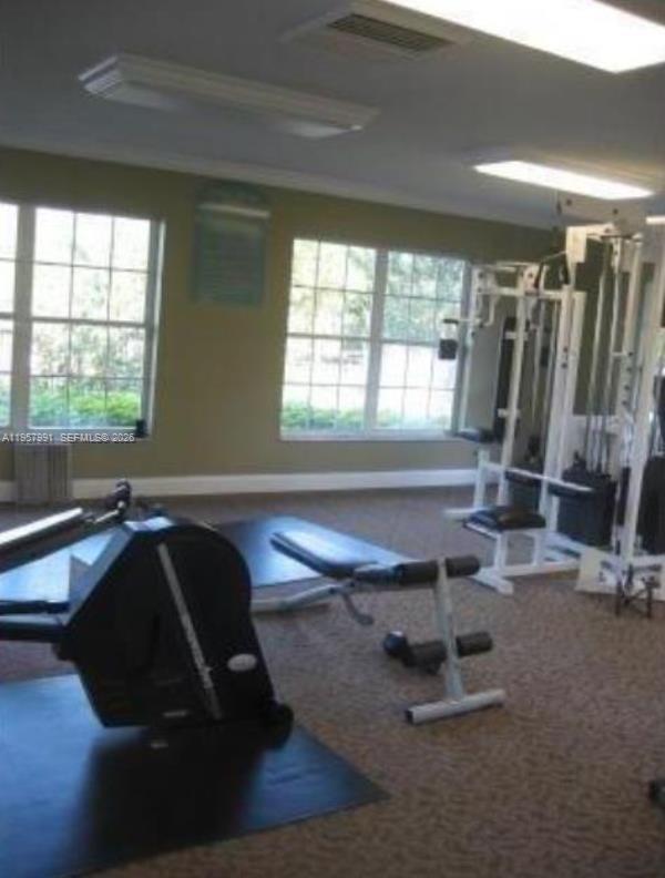 4055 West McNab Road, Unit H311 Pompano Beach, FL 33069 - Photo 12 of 14 a room with gym equipment and a large window