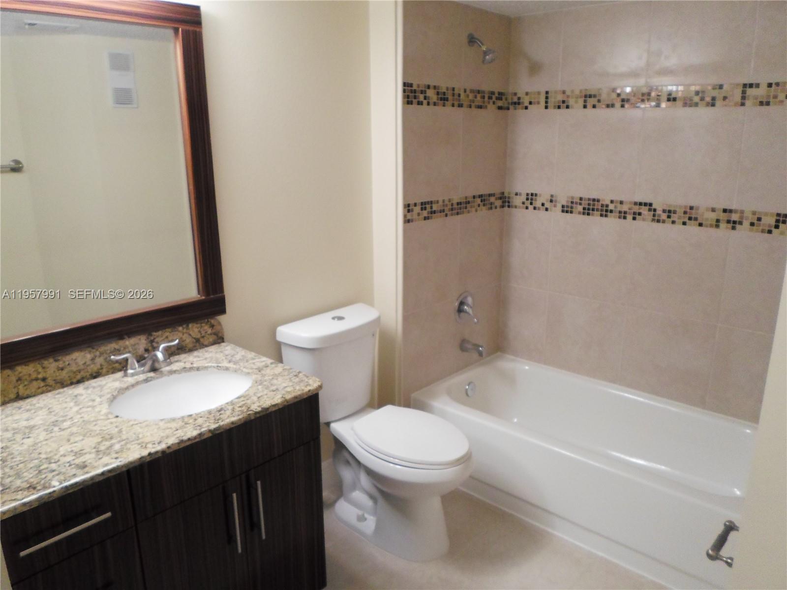 4055 West McNab Road, Unit H311 Pompano Beach, FL 33069 - Photo 5 of 14 a bathroom with a granite countertop sink toilet and shower